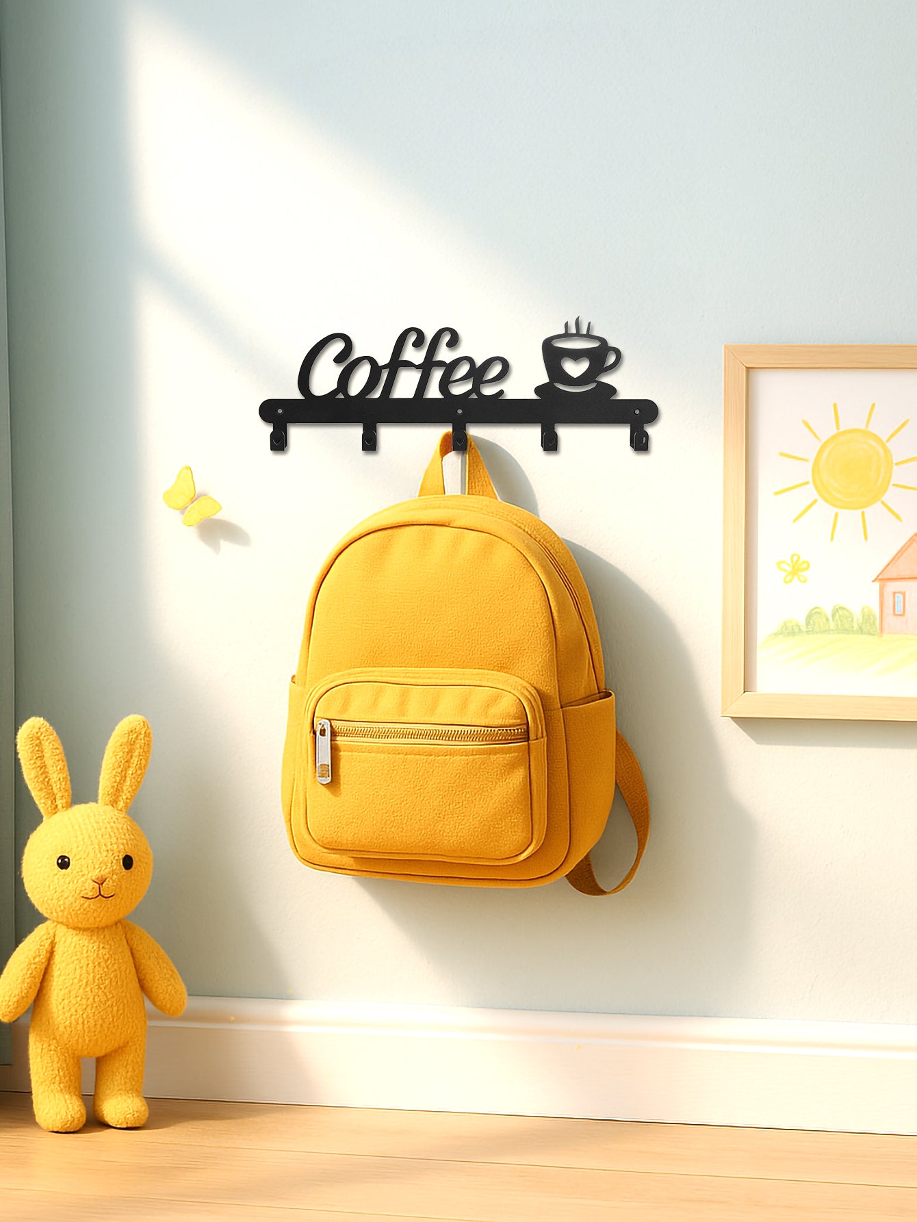 Black wall-mounted coffee mug holder rack with coffee motif, holding a yellow bag