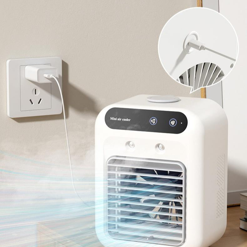 Ivory mini air cooler fan near a wall outlet, with front grille and control panel